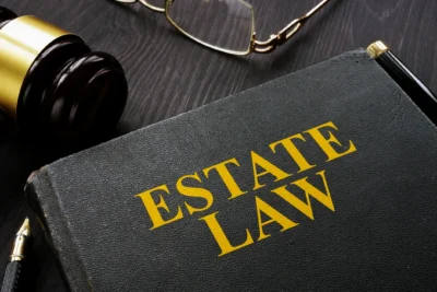 Estate law book with gavel and glasses.